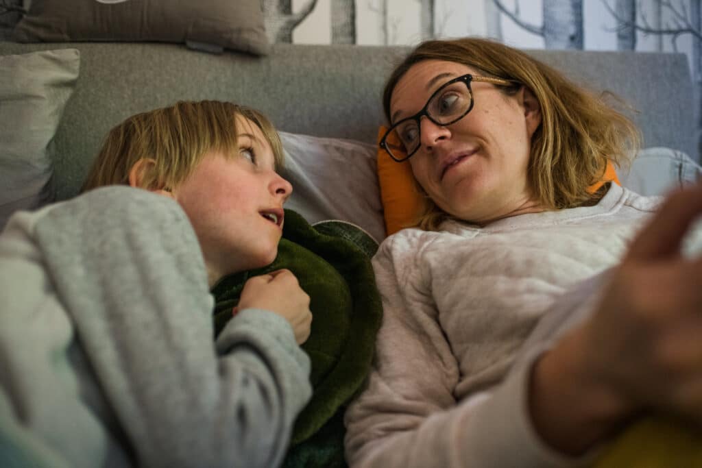 mom and son laying on a bed and having some eceryday moments together