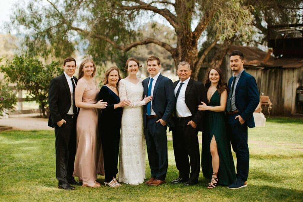 formal portrait of family with bride and groom in a lawn