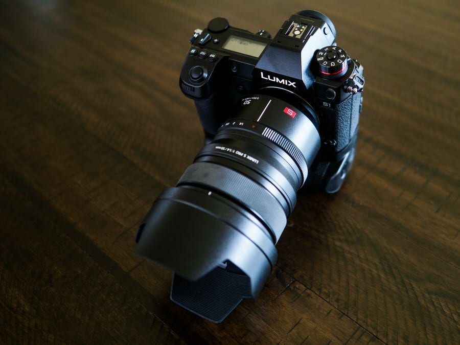 lumix panasonix camera in black color placed on wooden surface