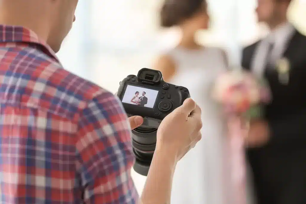 photographer checking bride and grooms picture