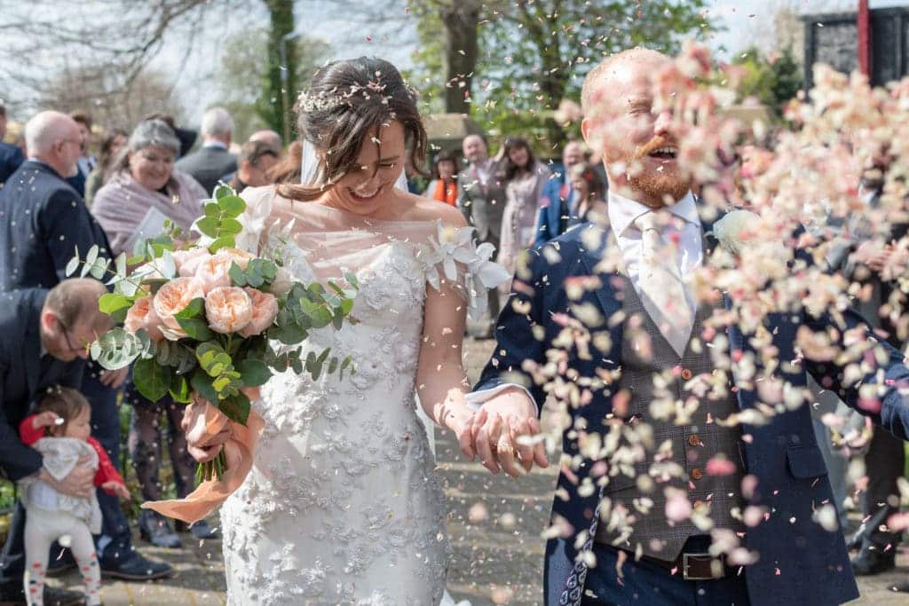 raw picture of bride and groom celebrating their event bride holding a bouquet in the presence of guests