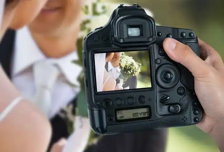 someone taking picture of bride and groom in a camera