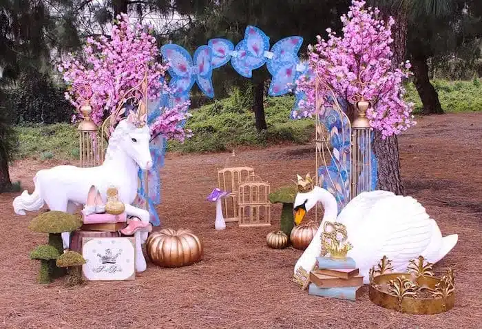 fairy tale themed decor for birthday in outdoor space unicorn swan and pink flowers