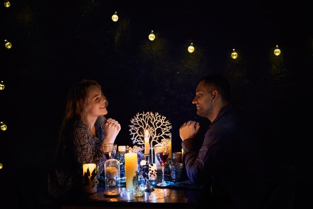 A Romantic Couple Sharing A Candlelit Dinner The Dimly Lit