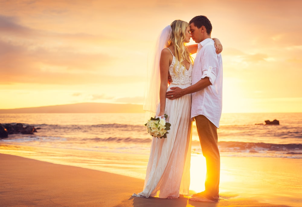 Bride And Groom Kissing At Sunset On A Beautiful Tropical Beach