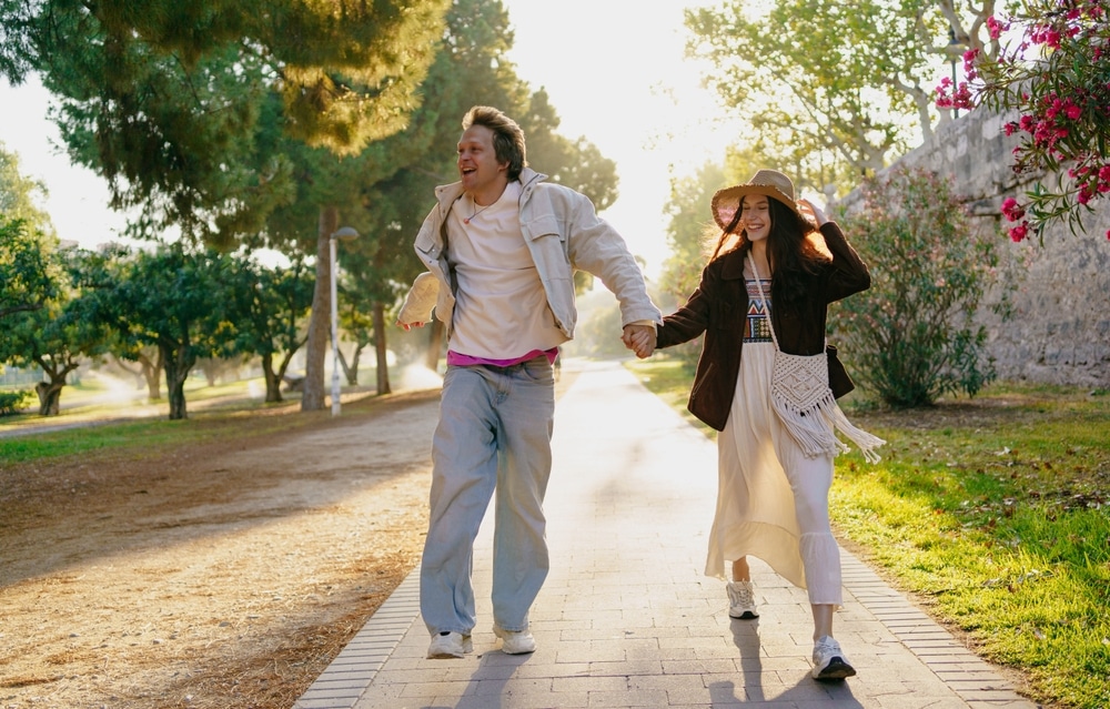 A Joyful Couple Walking Hand in Hand in a Beautiful Natural Setting Surrounded by Trees