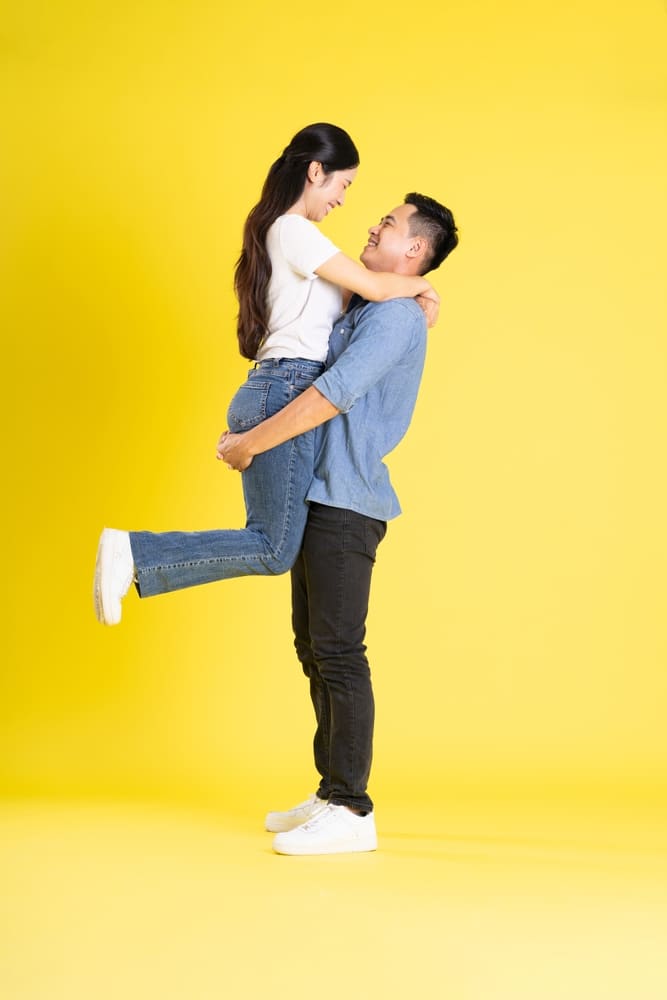 asian couple in lift pose on a yellow background 